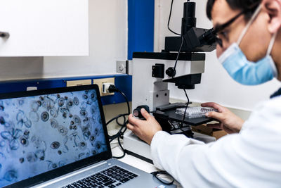 Male scientist using microscopy in laboratory