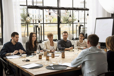 Business people taking interview against window in office