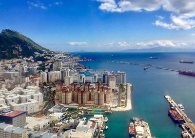 High angle view of city by sea against sky