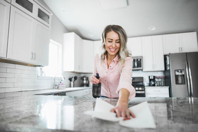 Low angle view of woman cleaning kitchen counter at home