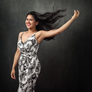 Portrait of a smiling young woman over black background