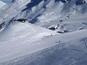 Scenic view of snowcapped mountains on sunny day