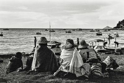 Rear view of people sitting on beach