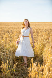 Portrait of smiling young woman standing on field