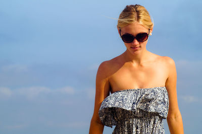 Beautiful young woman against sky