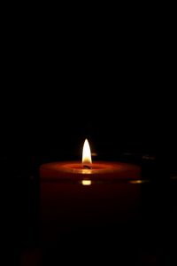 Close-up of lit candle in darkroom