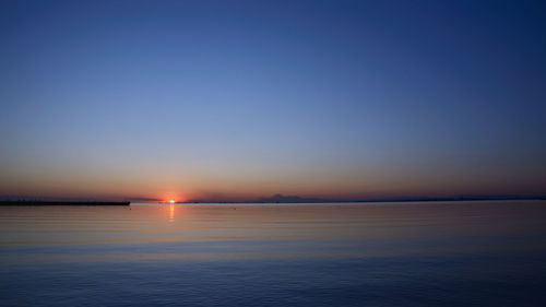 Scenic view of sea against clear sky at sunset