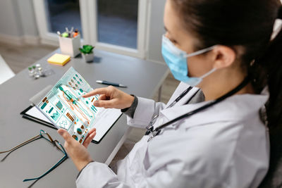 Female doctor working with medical digital diagnostic on transparent tablet