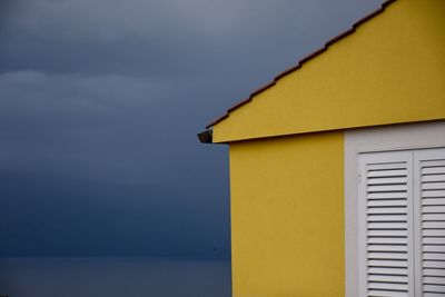 Close-up of yellow building against sky
