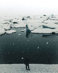 High angle view of person standing at snow covered beach