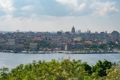 River by cityscape against sky