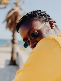 Close-up portrait of young man wearing sunglasses while sitting outdoors