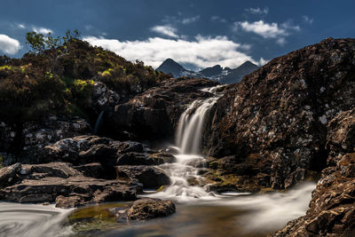 Scenic view of waterfall against sky