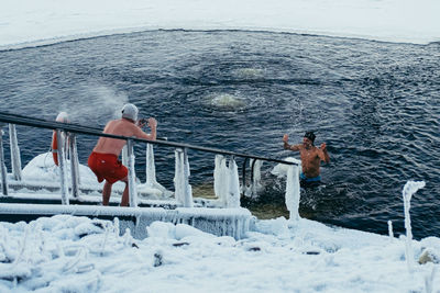 Men in sea during winter