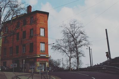 Road by building in city against sky