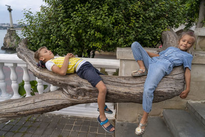 Portrait of woman sitting on bench at park