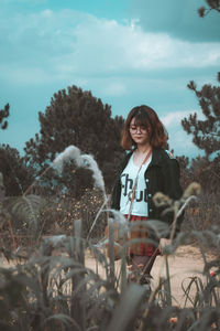 Portrait of smiling young woman against plants