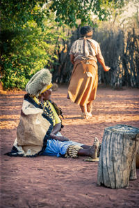 Rear view of couple sitting on tree