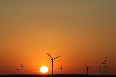 Silhouette of wind turbines on landscape