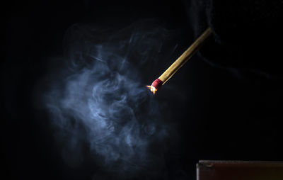 Close-up of burning match box against black background