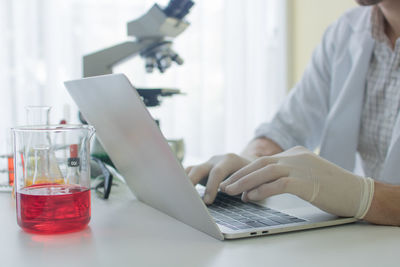 Midsection of man using laptop on table