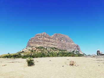 Scenic view of rocks against clear blue sky