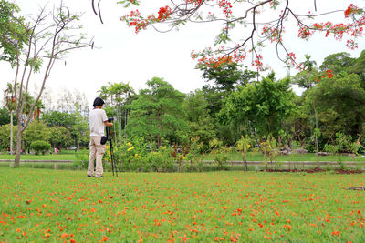 Rear view of woman standing on field