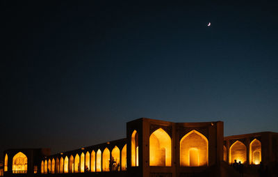 Low angle view of illuminated bridge against sky at night