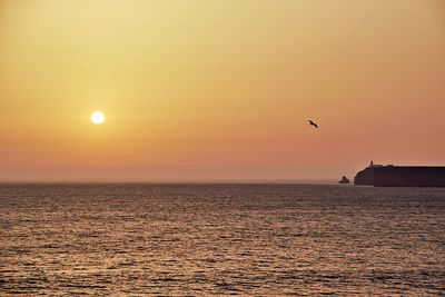 Scenic view of sea against orange sky