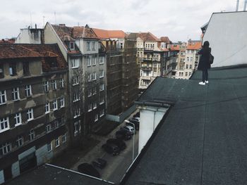 Woman standing on rooftop of building in city