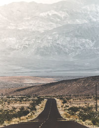 Scenic view of road by land against sky