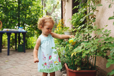 Cute girl standing against plants