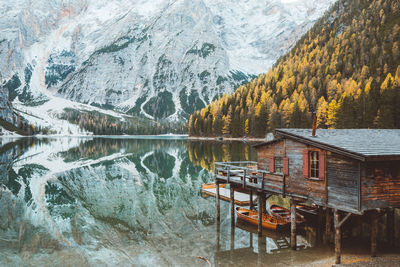 Scenic view of lake with stilt house by mountains