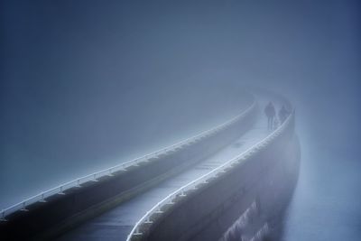 Aerial view of illuminated bridge against blue sky