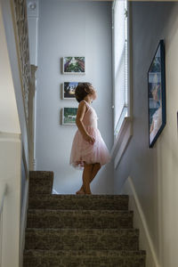 Rear view of woman standing by staircase