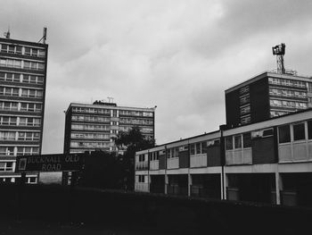Low angle view of buildings against cloudy sky