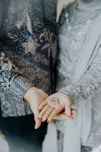 Midsection of couple holding hands