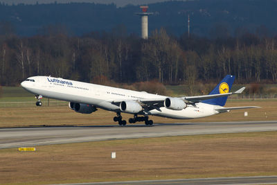 Side view of airplane on airport runway against sky