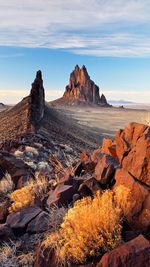 Scenic view of rock formations on field against sky