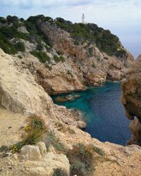 Rock formations by sea against sky