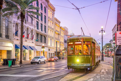 Cars on illuminated city street against sky