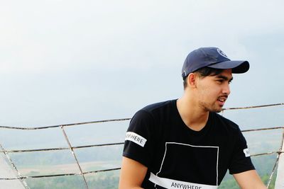 Young man standing by railing