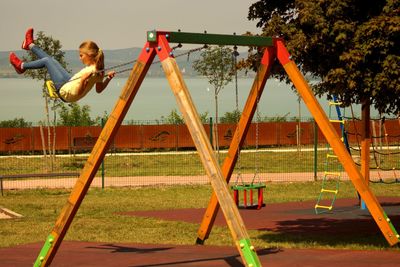 Boy playing at playground against sky