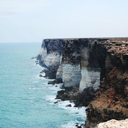 Rock formation in sea against sky