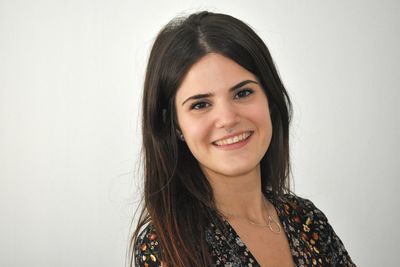 Portrait of smiling young woman against white background