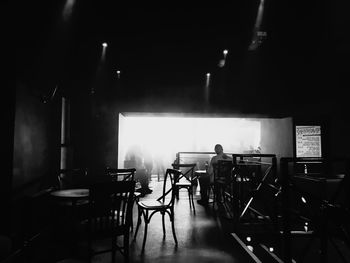 Empty chairs and tables in illuminated room