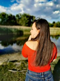 Young woman looking away while standing outdoors