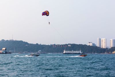 People on sea against clear sky