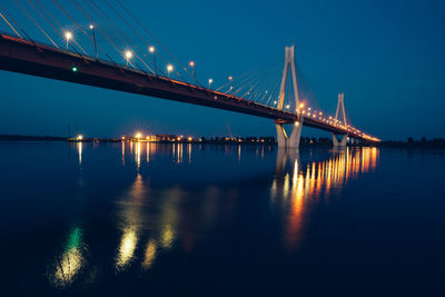 Night glowing bridge over the river