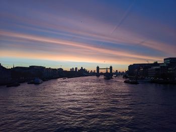 Scenic view of sea and buildings against sky during sunset